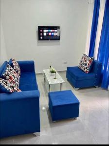 una sala de estar con 2 sofás azules y una mesa. en Apartamento la familia 2, en Santa Bárbara de Samaná