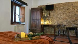 um quarto com uma cama e uma parede de pedra em La Clerecia de Ledesma em Ledesma