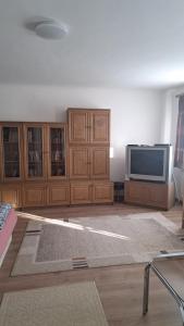 una sala de estar con TV y armarios de madera. en Villa Julia, en Budapest