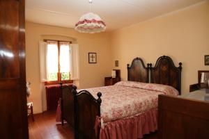 um quarto com uma cama e um lustre em Al Vecchio Leccio em Pistoia