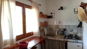 uma pequena cozinha com um lavatório e uma janela em Granja La Lechuza Ecolodge em Oberá