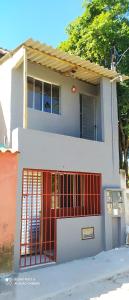 una casa blanca con una puerta roja delante de ella en Mini Casa em Arraial d'Ajuda en Porto Seguro