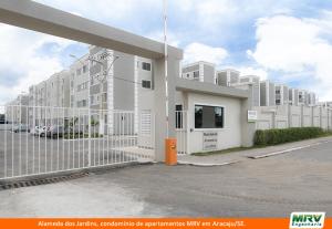 a white building with a fence in front of it at RESIDENCIAL ALAMEDA JARDINS in Aracaju