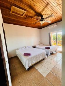 two beds in a room with a wooden ceiling at Sunset Views Apartment, West End in West End