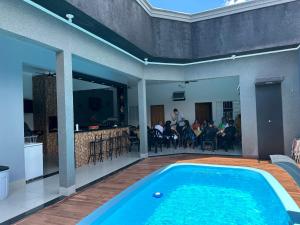 a swimming pool in the middle of a patio with people eating at Área de Lazer morada do sol in Sao Jose do Rio Preto