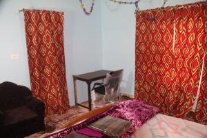 a room with red and gold curtains and a table at Baba BabaBah in Srinagar