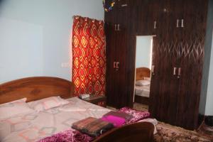 a bedroom with a bed and a large mirror at Baba BabaBah in Srinagar