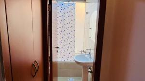 La salle de bains est pourvue d'un lavabo et d'un rideau de douche. dans l'établissement Nicest Partition Room in Barsha Heights Near Internet City Metro, à Dubaï