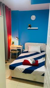 Schlafzimmer mit einem Bett mit blauer Wand in der Unterkunft Nicest Partition Room in Barsha Heights Near Internet City Metro in Dubai