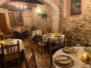 a restaurant with white tables and chairs with candles at La Clerecia de Ledesma in Ledesma