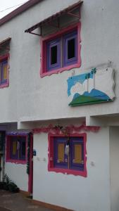 a building with colorful windows on the side of it at Hostal Palmas De Cocora in Salento