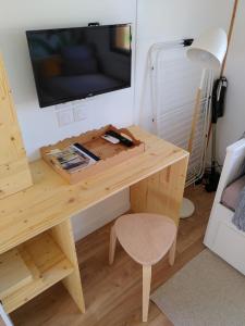 Maison sur pilotis في سان باليه: طاولة خشبية مع تلفزيون على الحائط