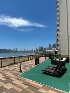 una fila de sillas en un paseo junto a la playa en Apartamento com ótima vista para o mar em BC, en Balneário Camboriú