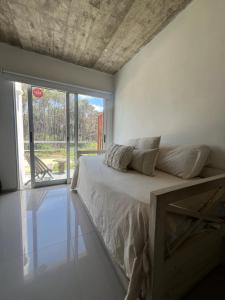 a bedroom with a bed and a large window at Arenas Garzón A 8 in José Ignacio