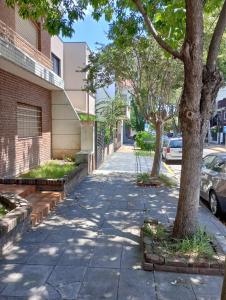 un marciapiede di fronte a un edificio con un albero di Bright brand new studio a Olivos