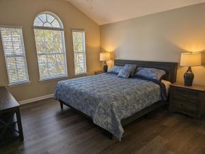 a bedroom with a bed and two windows at Cedar's Corner In Concord Spacious & Clean in Huntersville