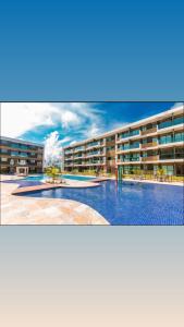 Flat com vista para piscina principal في إيبوجوكا: عمارة سكنية كبيرة بها مسبح