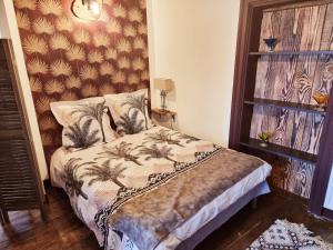 ein Schlafzimmer mit einem Bett mit einer Wand in der Unterkunft Prestigieuse Résidence : N°6 in Bellac