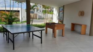 Flat com vista para piscina principal في إيبوجوكا: طاولة بينج بونغ في غرفة مع طاولة بلياردو