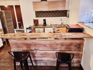 eine Küche mit einer Holztheke mit 2 Stühlen in der Unterkunft Prestigieuse Résidence : N°6 in Bellac