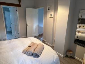 a bedroom with two towels on a bed at Beech Cottage in Ilfracombe