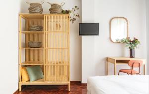 estante de libros de bambú en un dormitorio con cama en La casa del artista en Santander