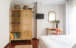 1 dormitorio con cama y estante con cestas en La casa del artista en Santander