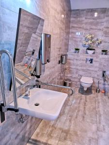 a bathroom with a white sink and a toilet at Hotel Węgierki in Września