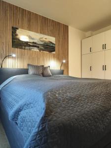 ein Schlafzimmer mit einem großen Bett mit einer blauen Decke in der Unterkunft Ferienwohnung Ott in Bad Endorf