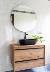 baño con lavabo negro y espejo en La casa del artista en Santander