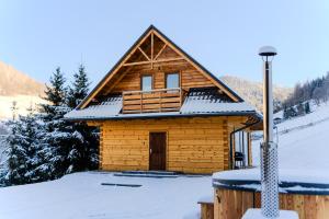 Cabaña de madera con nieve en el suelo en Domek w Górach, en Wierchomla Wielka