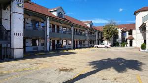 Un estacionamiento vacío frente a un edificio en Scottish Inn & Suites Sam Houston Parkway, en Houston