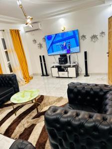 a living room with a tv and a couch and a table at Johen Residence in Douala