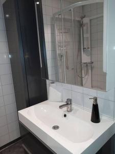 een witte badkamer met een wastafel en een douche bij Seaside in Tromsø