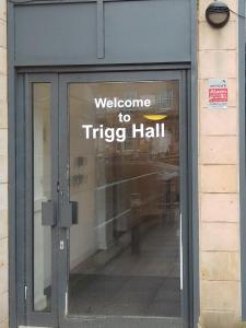 a welcome to triig hall sign on a glass door at Trigg Hall in Bradford