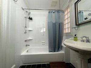 Baño blanco con bañera y lavamanos en Stupendous Apartment Steps From the Capitol!, en Washington