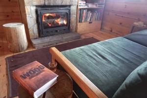 Habitación con chimenea, cama y libro en Guest House Montana en Kopaonik