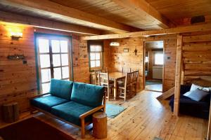 ein Zimmer mit einem Sofa und einem Tisch in einer Hütte in der Unterkunft Guest House Montana in Kopaonik