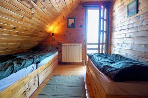 Habitación con 2 camas en una cabaña de madera en Guest House Montana en Kopaonik