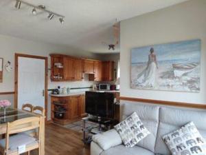 a living room with a couch and a kitchen at Tranquility Portstewart in Portstewart