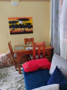 ein Wohnzimmer mit einem Tisch und einem Stuhl mit einem Sofa in der Unterkunft IMMARA BNB in Nakuru