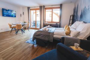 a living room with a bed and a table with chairs at ALPSTAY Eulennest - Ski-In & Ski-Out in Bad Kleinkirchheim