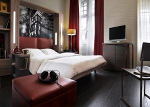 ストラスブールにあるAparthotel Adagio Strasbourg Place Kleberのベッド2台とテレビが備わるホテルルームです。