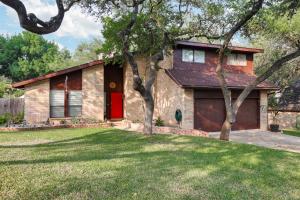 a house with a red door and a yard at Rakuen - A Birdy Vacation Rental in San Antonio