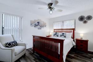 a bedroom with a bed and a chair and a ceiling fan at Rakuen - A Birdy Vacation Rental in San Antonio