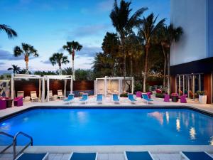 肯德爾的住宿－邁阿密戴德蘭雅樂軒酒店，一座带躺椅的游泳池和一座建筑