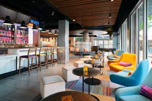 un restaurante con sillas y mesas y un bar en Aloft Miami Dadeland, en Kendall