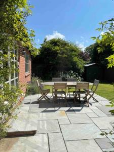 a patio with a table and chairs in a garden at Lovely quiet cottage Sleeps 4 adults, 4 children, Dog Friendly in Cley next the Sea