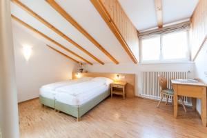 um quarto com uma cama, uma secretária e uma mesa em Berggasthof Locanda Alpina Dorfner em Montagna