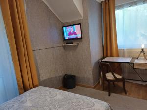 a hotel room with a television on a wall at Chambresdhoteslaforet com in Longwy